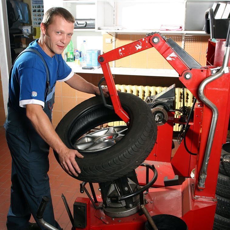 Ein Mitarbeiter der Heduschka GmbH beim Reifenwechsel an der Montiermaschine